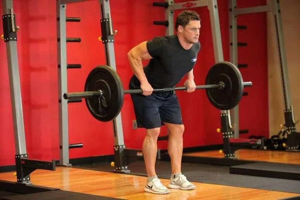 Homem treinando remada curvada